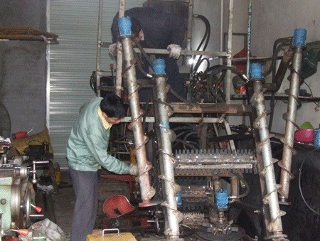 王坚调试甘蔗收割机的访谈配图。原文有明确姓名图注；机器具体型号与拍摄时间未标明。 / Interview illustration showing Wang Jian commissioning a sugarcane harvester. The original has a caption explicitly naming him; the exact machine model and photography date are not given.